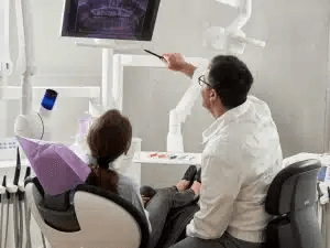 A dentist consulting with a patient about denture options at a private clinic