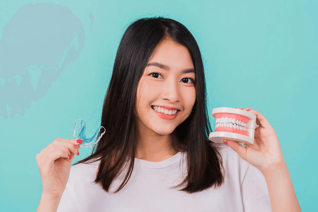 Person carefully removing clear Invisalign aligners