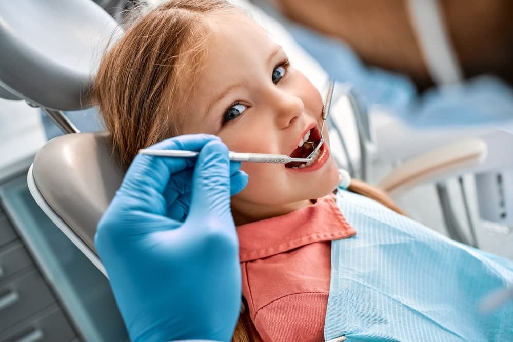 Parent helping child brush teeth for good oral health