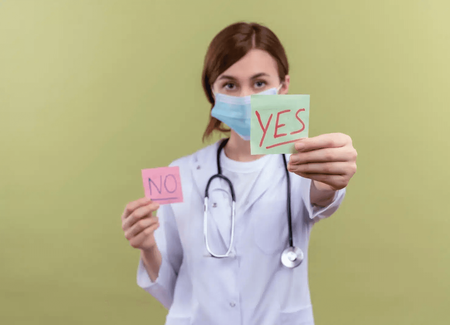 A young female dentist wearing a white robe and a stethoscope holds Post-it notes with 'yes' and 'no' written on them and extends the 'yes' note towards the camera.
