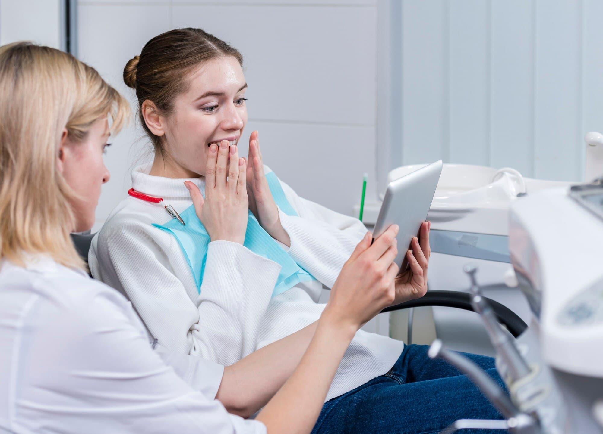 A dental patient looks ecstatic as her dentist shows her a chart.