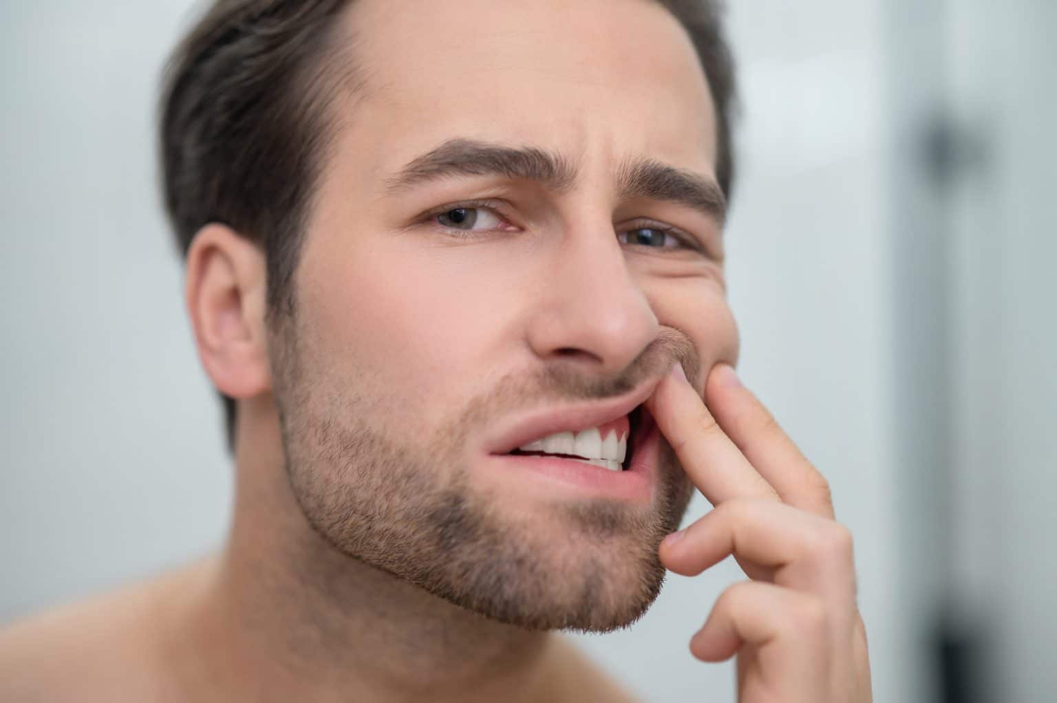 A dentist examining a patient for dry mouth and gum disease symptoms