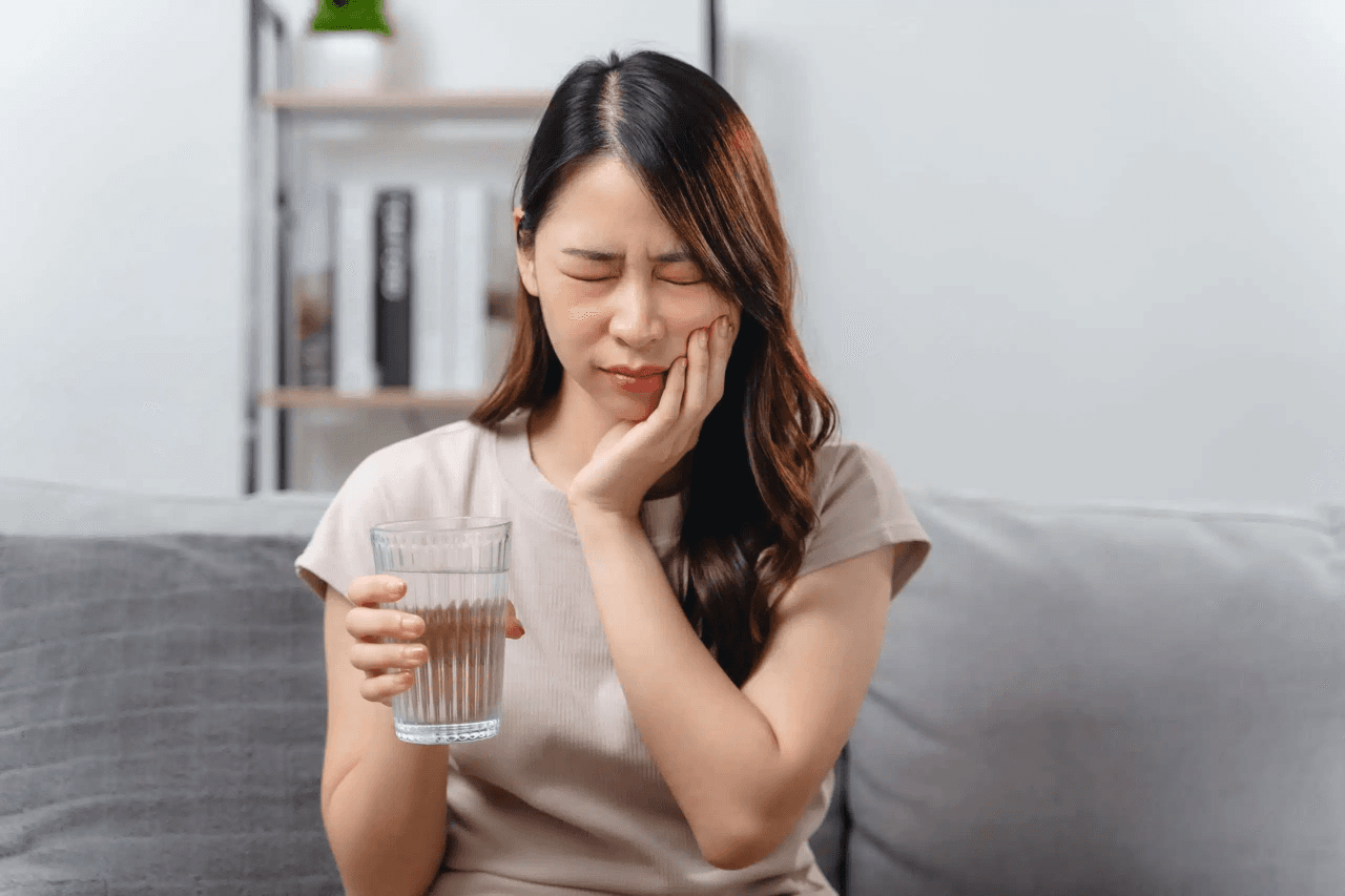Person holding their jaw in discomfort