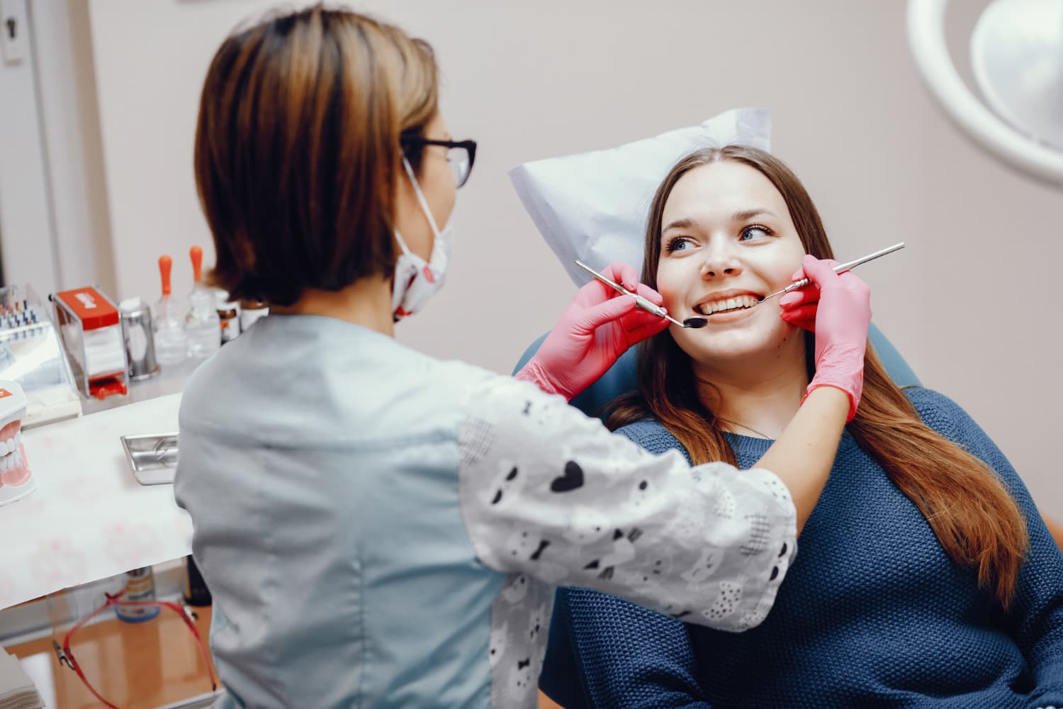 A dentist examining a female patient for dental implants in London.