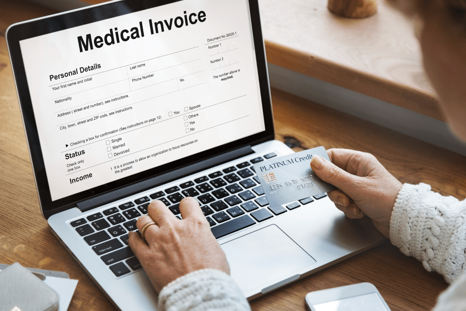 A person looks at a medical invoice on a laptop.
