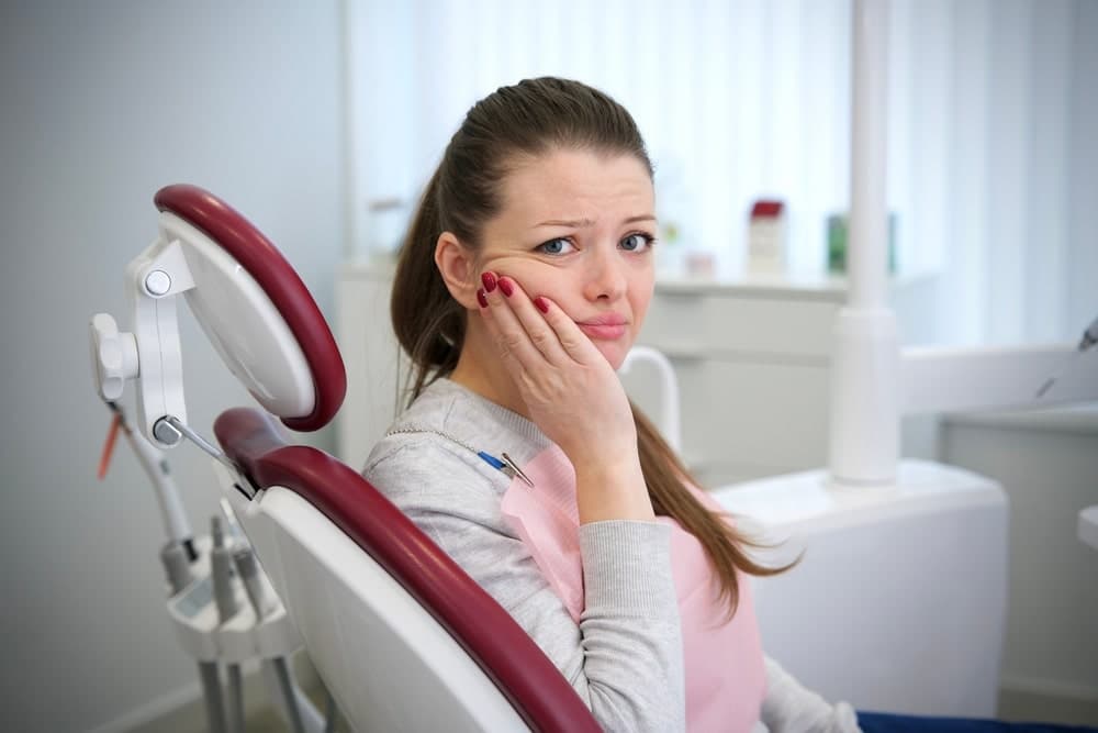 Person experiencing tooth sensitivity from a cold drink