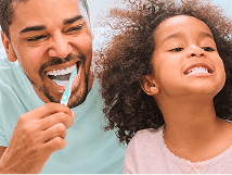 Patient brushing teeth with their child